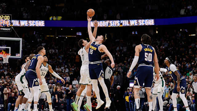 Denver Nuggets center Nikola Jokic (15) and Milwaukee Bucks center Brook Lopez (11) tipoff